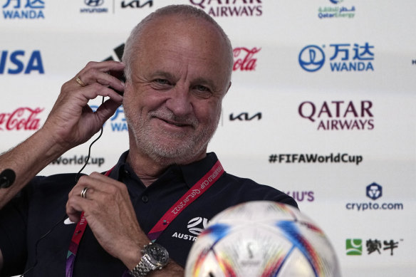 Graham Arnold fiddles with an earpiece at the 2022 World Cup, where the translation he was hearing was delivered by a human interpreter, under pressure.