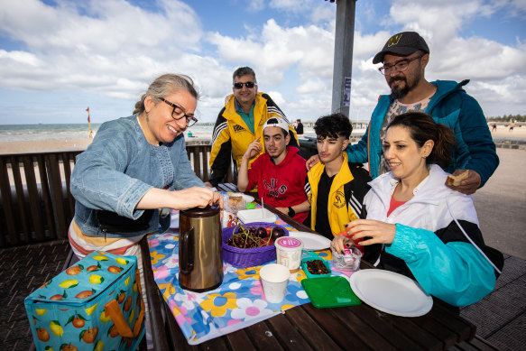 Mani Mirfeizi (far left) husband Hamid (in yellow jacket) and son Arshia (in red) with Rachele Hesari (right), husband Farzae and son Korosh,15 (in yellow) at Altona Beach on Australia Day.