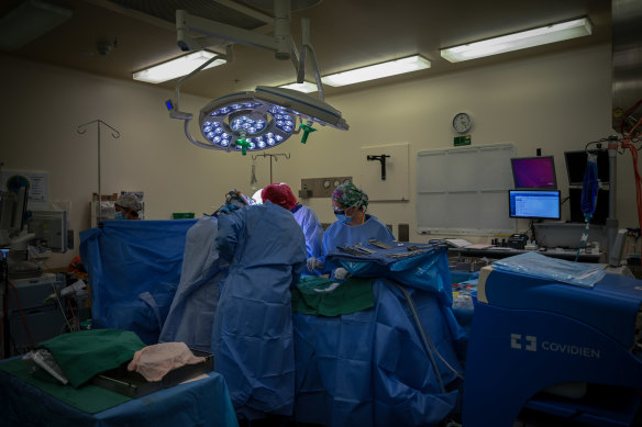 Rob lying in theatre surrounded by a team of specialists. 