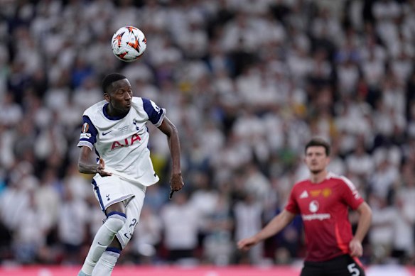Tottenham’s Pape Matar Sarr, left, heads the ball past Manchester United’s Harry Maguire.
