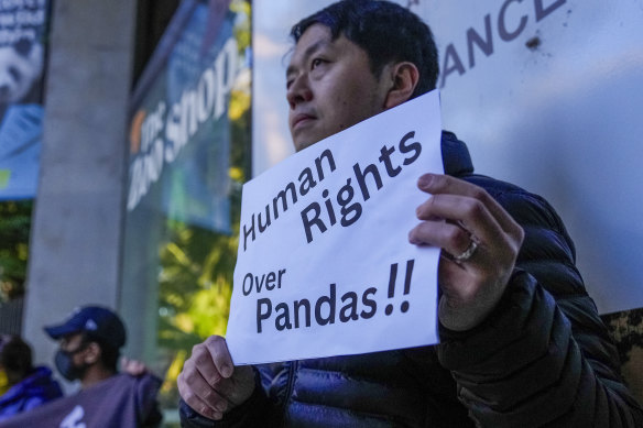 A protester holds a placard ahead of a visit by Chinese Premier Li Qiang to Adelaide Zoo as part of a four-day Australian visit.
