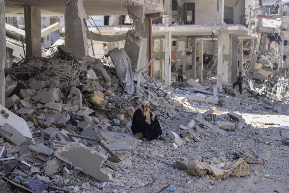 A Palestinian woman talks on her phone from the rubble of her home after an Israeli air and ground offensive in Jebaliya, northern Gaza Strip on Friday. 