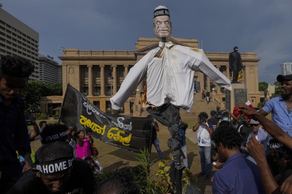 Protesters prepare to burn an effigy of acting president and Prime Minister Ranil Wickremesinghe.