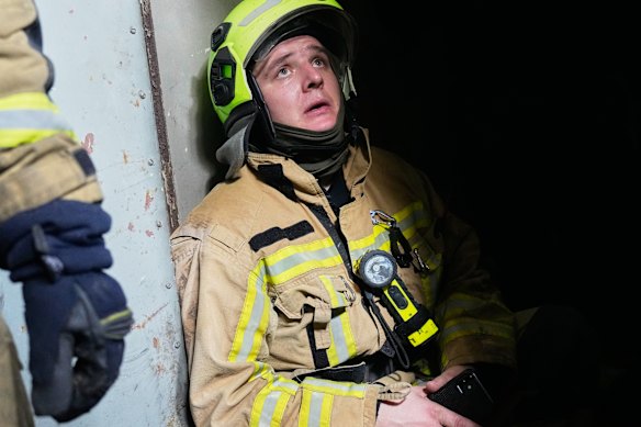 A Kyiv firefighter listens to the sound of an incoming drone as he shelters during a Russian air raid.
