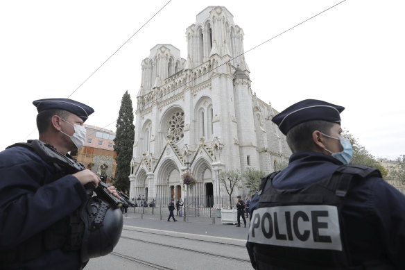 Police officers stand guard near Notre Dame church in Nice after an attacker beheaded a woman and killed two others.