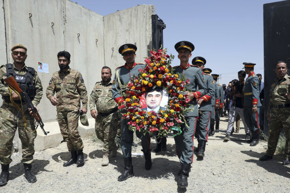 Afghan honour guards hold a wreath of flowers containing a portrait of Dawa Khan Menapal, director of Afghanistan’s Government Information Media Centre who was shot and killed in Kabul on August 6.