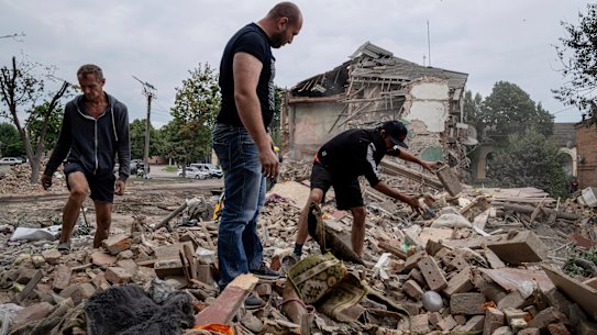 Residents search the debris of a destroyed house after Russian shelling in the Kharkiv region of Ukraine.