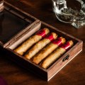 Duck-filled pastry cigars come with foil tips and are presented in a cigar box.