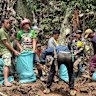 Workers and volunteers filling sandbags near the entrance of the flooded cave containing seven trapped villagers.