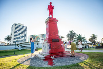 Locals take photographs of the vandalised monument in St Kilda. 