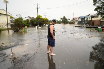 James Brady inspects flooding in his street.
