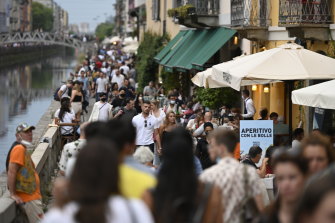 Visitors walk past restaurants in the Navigli suburb of Milan, Italy, last month.