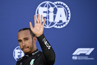 Lewis Hamilton waves as he walks back to the pits after his crash in qualifying.