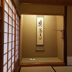 "Drink the tea": the scroll on the wall.