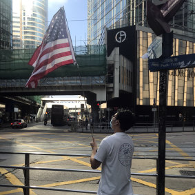 Leo, 20, with an American flag during and a lunch-time protest in Central, Hong Kong, on Wednesday. 