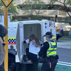 Disrupt Burrup Hub protestor Kristen Morrissey being escorted from Woodside’s headquarters.