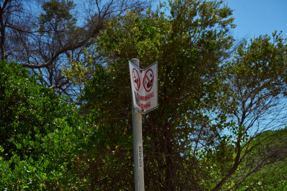 A partially bent no swimming and fishing sign at Tower Beach.