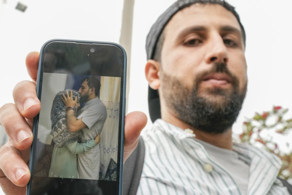 Kassem Abo Zeed holds up a phone displaying a photo of himself with his wife, Ezra – who is missing after a fishing boat carrying migrants sank off southern Greece – in the southern port city of Kalamata.