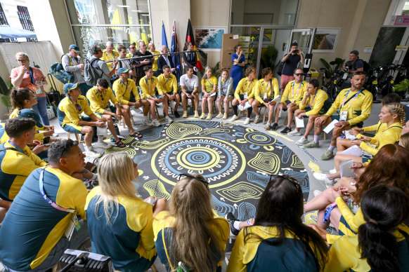 Australia’s swimmers arrive at the village and sit around the “yarning circle”.