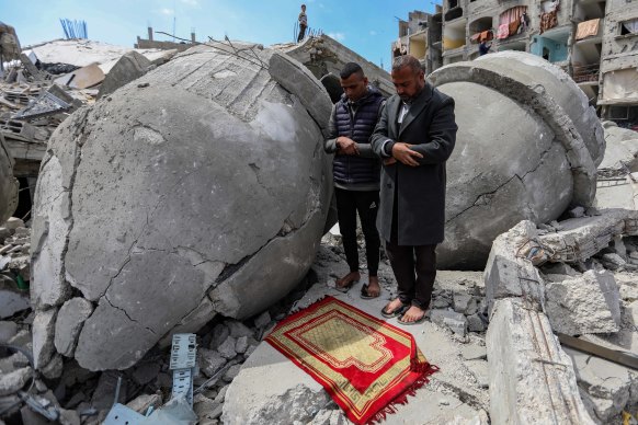 Palestinians pray during the second Friday prayer of the holy month of Ramadan on the ruins of Al-Farouq Mosque, which was destroyed by Israeli air strikes in Rafah, Gaza. 