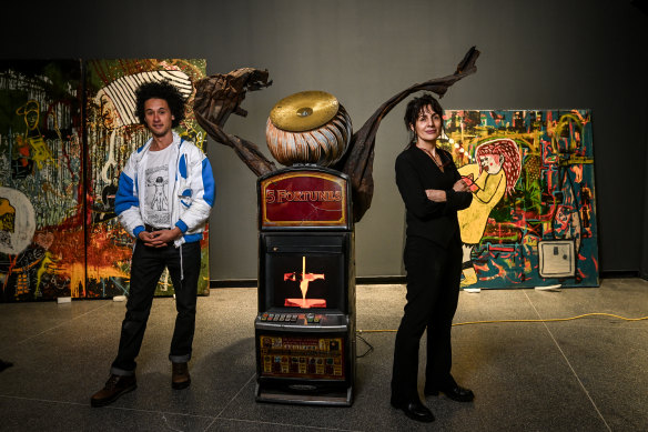 Levi McLean and curatorial adviser Dr Erica Izett with one of the poker  machine artworks.