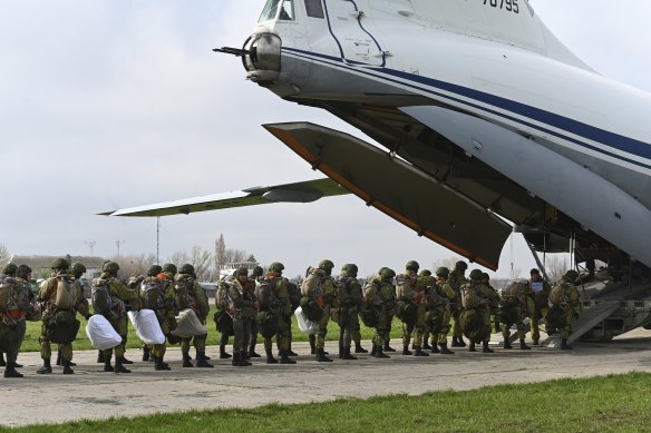 Russian paratroopers load into a plane for airborne drills on Thursday.