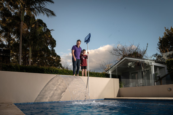 Mark Jones and his son Ethan, 8, in front of the swimming pool powered by Pooled Energy.
