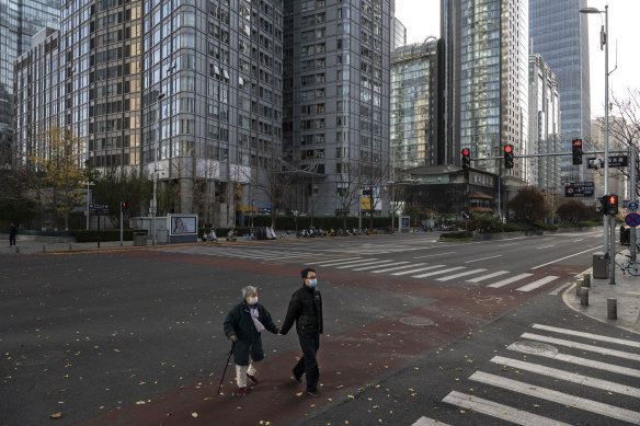 People walks across an empty street in the Beijing CBD on Friday.