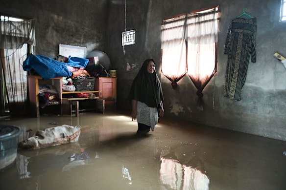 A woman stands inside her flooded house in Indonesia’s Pidie Jaya, in Aceh province, on Wednesday.