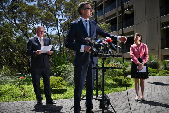NSW Treasurer Dominic Perrottet addresses the media, flanked by Health Minister Brad Hazzard and Premier Gladys Berejiklian.