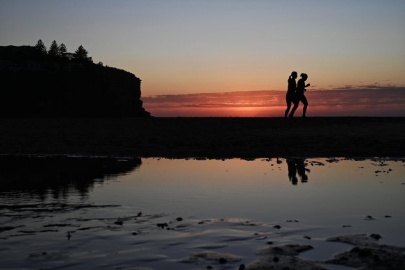Smoke from hazard-reduction burns adds to the dawn glow over Avalon Beach in Sydney's north as winter makes way for spring.