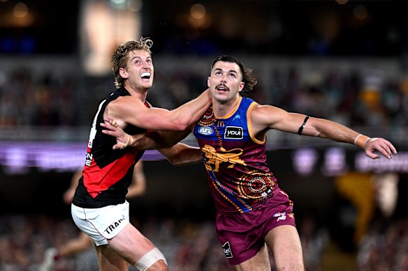 Nick Bryan of the Bombers and Sam Draper of the Lions compete for the ball.