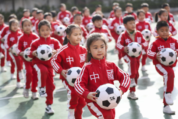 Children perform football rhythmic exercises in Huaian, Jiangsu Province, China, on Thursday.
