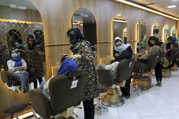 Beauticians put makeup on customers at Ms Sadat’s Beauty Salon in Kabul.
