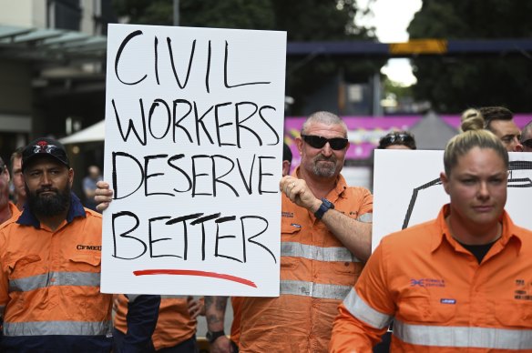 Striking CFMEU members, who work on the Albert Street Cross River Rail construction site, hold signs outside the site this week.