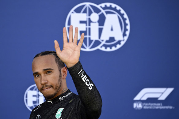 Lewis Hamilton waves as he walks back to the pits after his crash in qualifying.