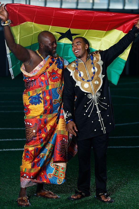 Father and son hold up the Ghanaian flag.