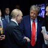 Trump and Putin shake hands.