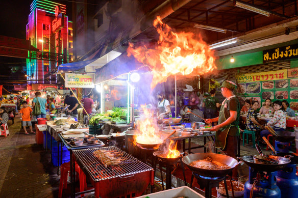 A chef cooks at a street side restaurant in Bangkok.