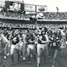 Peter Bosustow, premiership cup in hand and Carlton scarf flowing, leads the triumphant Blues on a victory lap of the MCG after the 1982 grand final.
