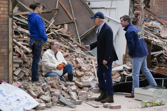 US President Joe Biden and Kentucky Governor Andy Beshear talk to people as they survey storm damage from tornadoes and extreme weather in Mayfield, Kentucky.