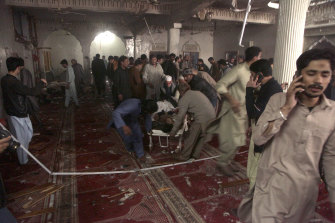 Rescue workers remove a victim from the site of a bomb explosion in a mosque in Peshawar. 