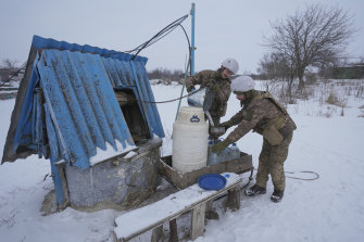 Ukrainian servicemen drawing water from a well near the frontline wait for am invasion that US President Biden thinks may come within weeks. 