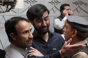 A man is comforted by others in the aftermath of the explosion. 