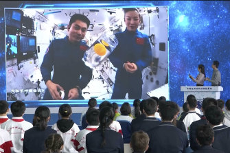 Astronauts Wang Yaping, right, and Ye Guangfu, demonstrate science experiments aboard the China Space Station. 