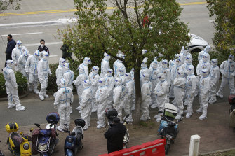 Workers in hazmat suits prepare to administer COVID-19 tests for employees at Shanghai Pudong International Airport.