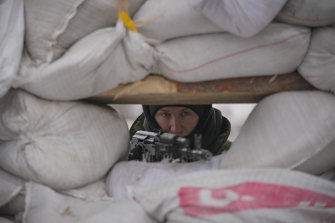 A Ukrainian serviceman mans a checkpoint in Kyiv on Monday. 