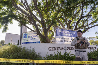An Orange County Sheriff’s Department officer guards the grounds at Geneva Presbyterian Church in Laguna Woods, California.