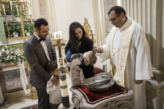Italy’s top court ruled that children born in the country will be given their mother’s and father’s surnames at birth. Pictured: a baptism in Catania, Italy,