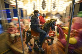 Children enjoy a carousel ride at a Christmas fair in Bucharest, Romania.